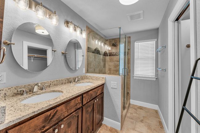 Bathroom featuring a walk in shower and double vanity | Image 12