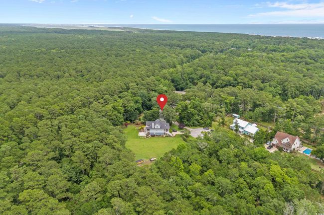 Aerial view of property and surrounding area with a heavily wooded area and a large body of water | Image 5