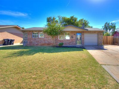 Ranch-style home featuring a front lawn and a garage | Image 1