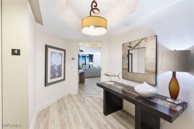 Hallway featuring a tray ceiling and light wood-type flooring | Image 3