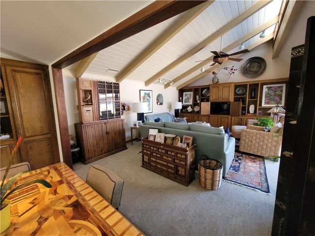 Carpeted living room with lofted ceiling with beams and a ceiling fan | Image 16
