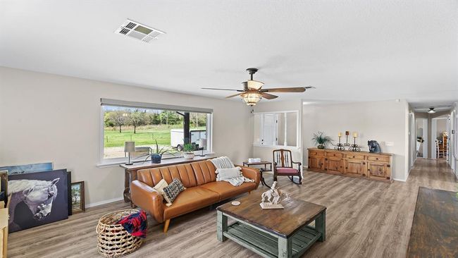 Living room with visible vents, ceiling fan, and light wood-type flooring | Image 34