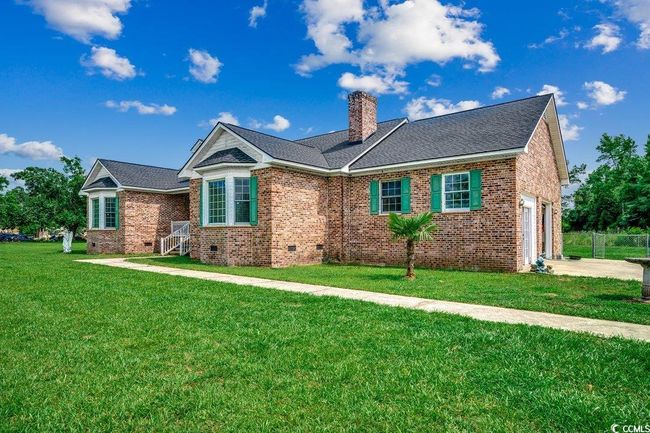 Single story home with a chimney, an attached garage, a front yard, brick siding, and concrete driveway | Image 24