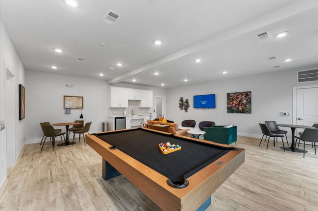 Entertain and relax in the game room, featuring a pool table, TV, and lounge seating. | Image 21