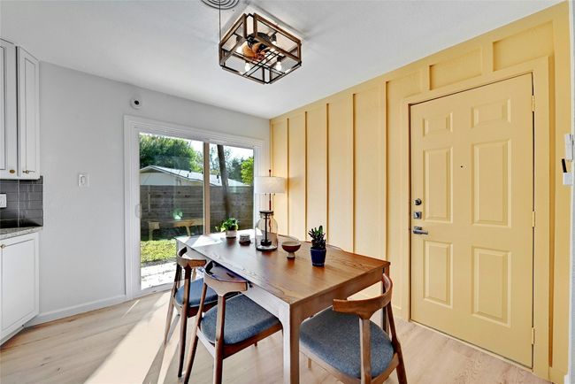 The sun-filled dining area features a ceiling fan/light fixture combo with direct access to the backyard. | Image 10