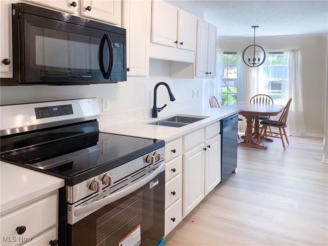 Sleek kitchen with updated vinyl floors, counters and appliances! | Image 16