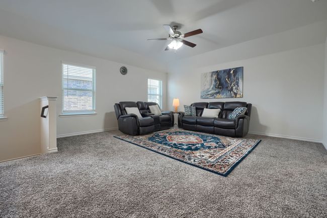Carpeted living area with a ceiling fan and baseboards | Image 23