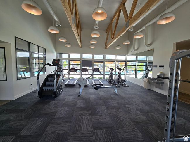 Exercise room featuring a high ceiling, carpet flooring, and baseboards | Image 26