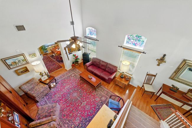 Living area with towering ceiling, healthy amount of natural light, and a ceiling fan | Image 8