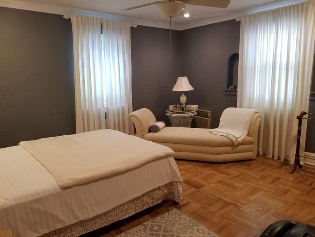 Bedroom with a ceiling fan and ornamental molding | Image 7