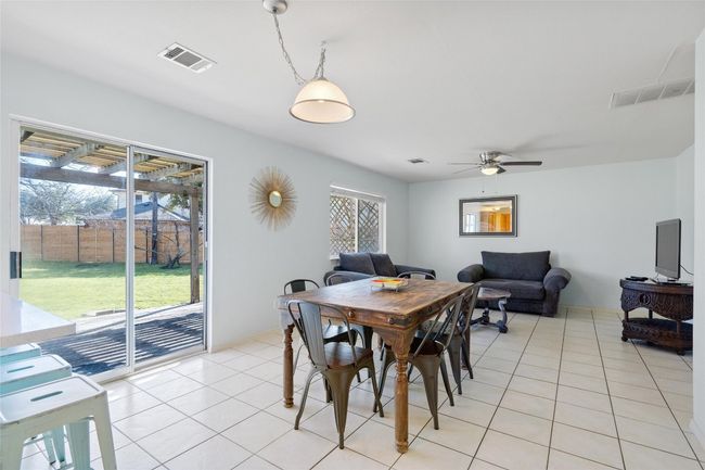Dining room with light tile patterned floors, ceiling fan, and visible vents | Image 14