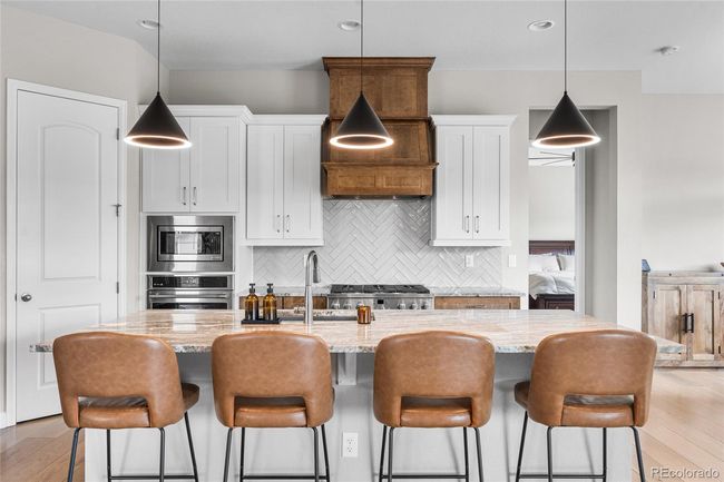 Chef's dream kitchen with upgraded pendant lighting, GE Cafe appliances (6-burner gas range, wall oven/airfryer, French door refrigerator) custom range hood and herringbone tile backsplash. Large granite island soft-close maple cabinets will roll-out drawers and large pantry. | Image 12