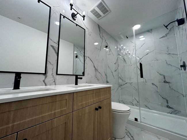 Bathroom with marble finish floor, toilet, a sink, visible vents, and a marble finish shower | Image 17