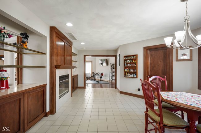dining space with baseboards, visible vents, an inviting chandelier, light tile patterned flooring, and a large fireplace | Image 19
