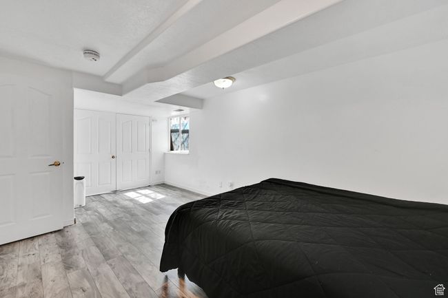 Bedroom with baseboards, light wood-style flooring, and a closet | Image 30