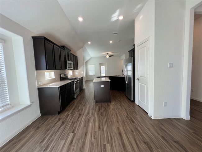 Kitchen featuring open floor plan, appliances with stainless steel finishes, dark cabinetry, dark wood finished floors, and recessed lighting | Image 11