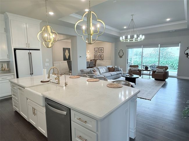 Kitchen featuring a raised ceiling, white cabinets, dark wood-style flooring, recessed lighting, and ornamental molding | Image 7