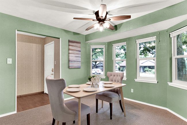 Dining room with carpet floors, a ceiling fan, and a textured wall | Image 9