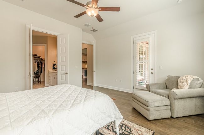 Bedroom with access to exterior, wood finished floors, baseboards, vaulted ceiling, and ceiling fan | Image 29