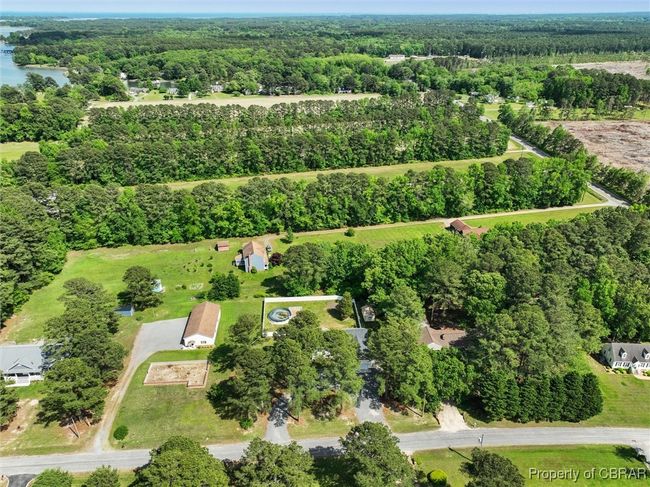 View of property location featuring a heavily wooded area and a nearby body of water | Image 39