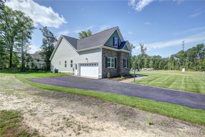 View of side of home featuring cooling unit, a garage, and a yard | Image 2