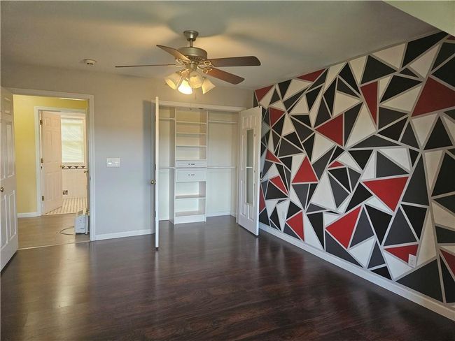 Unfurnished bedroom featuring ceiling fan, dark hardwood / wood-style flooring, and a closet | Image 26