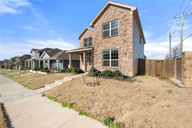 Traditional home with covered porch, brick siding, and fence | Image 38