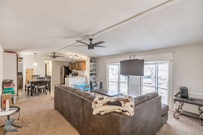 Living area featuring light carpet and a ceiling fan | Image 18