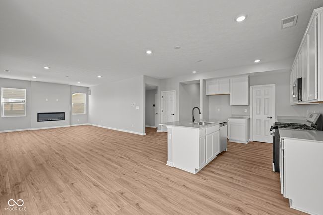 kitchen with open floor plan, a sink, stainless steel appliances, and light wood finished floors | Image 5