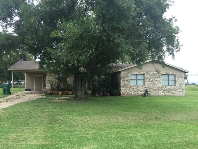 Front of 5111 #3 Tucker - Single story home featuring a carport, a front yard, stone siding, and dirt driveway | Image 7