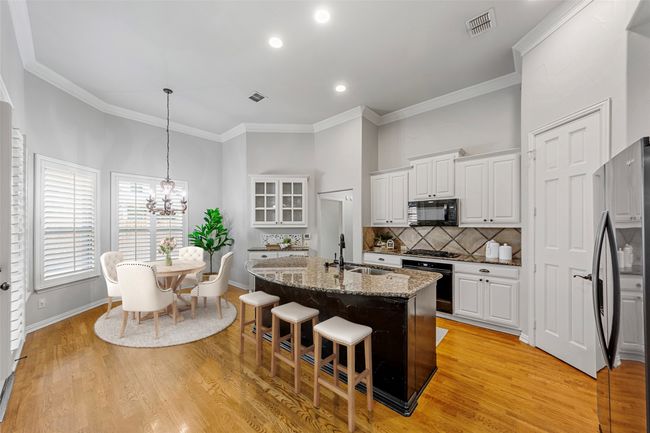 Kitchen featuring black appliances, a sink, a chandelier, stone countertops, and white cabinetry VIRTUALLY STAGED | Image 18