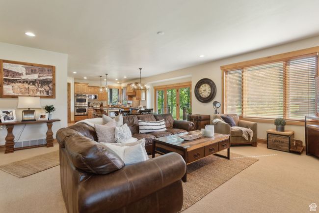 Living room featuring light colored carpet, recessed lighting, and a chandelier | Image 13