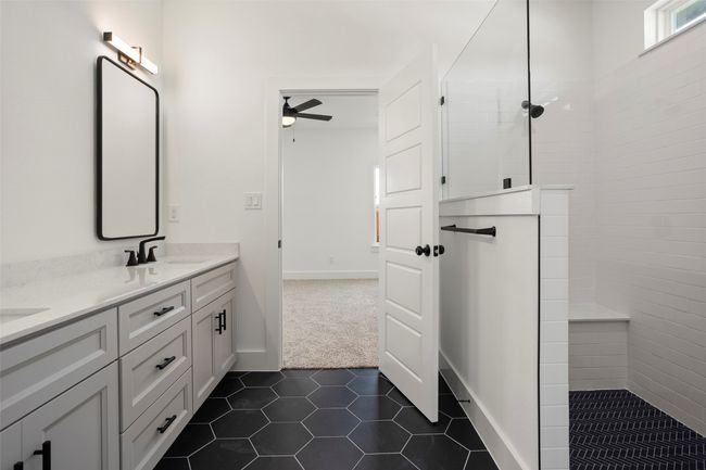 Bathroom featuring a tile shower, tile patterned floors, double sink vanity, and ceiling fan | Image 13