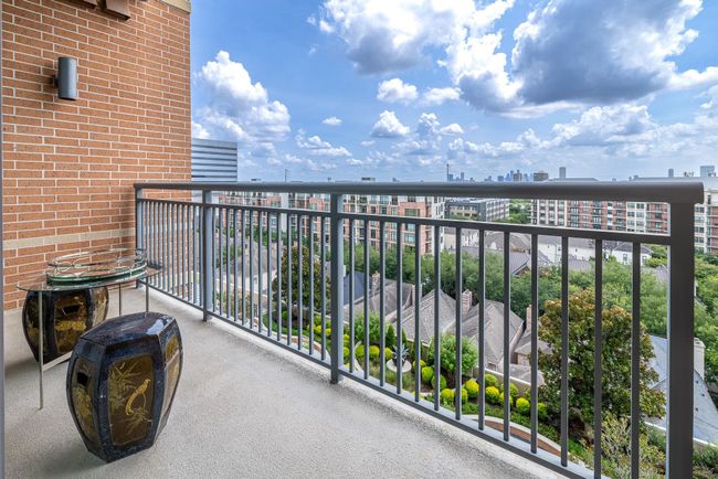 Spacious balcony with a cozy sitting area, offering stunning views of the city skyline. | Image 17