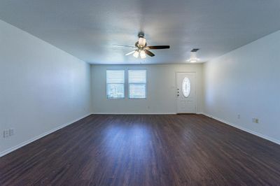 Empty room with ceiling fan, dark hardwood / wood-style flooring, and a textured ceiling | Image 2