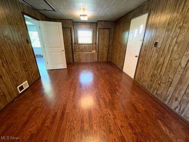 Family room or 3rd Bedroom featuring wood walls and wood finished floors | Image 13