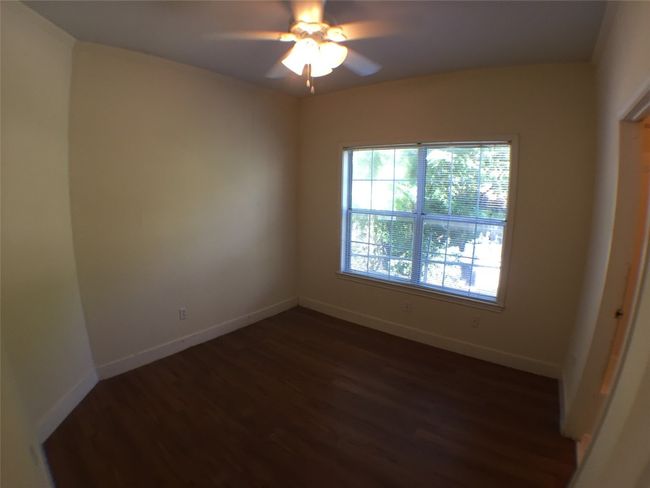 Spare room with baseboards, ceiling fan, and dark wood finished floors | Image 5