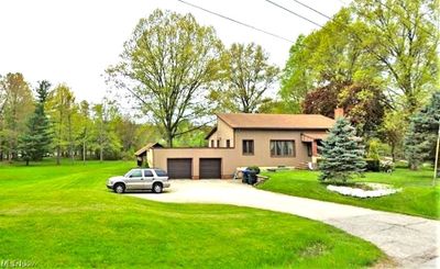 View of front of home featuring a garage and a front yard | Image 1