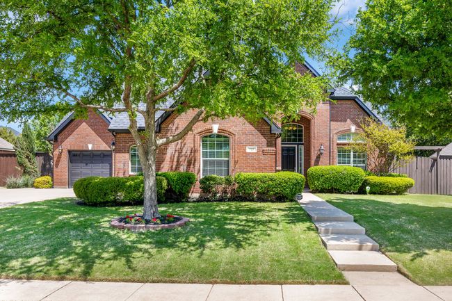 View of front of property with a garage, brick siding, fence, and a front lawn | Image 32
