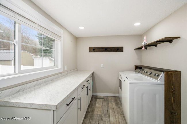 A functional laundry room with cabinets, drawers and a countertop for folding! | Image 17