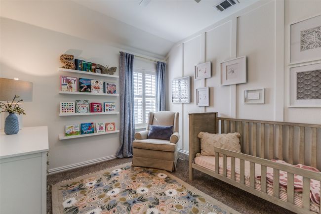 Bedroom number 2 with accent wall, bookshelves, and ceiling fan. | Image 18
