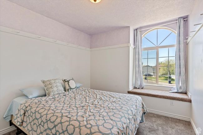 Bedroom with a large window, baseboards, a textured ceiling, and carpet flooring | Image 15