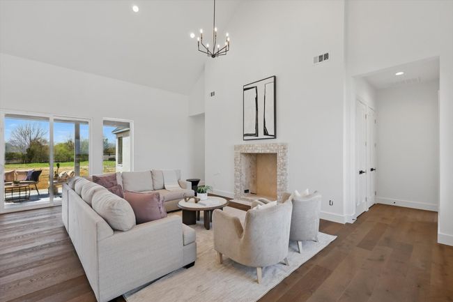 Living room featuring an inviting chandelier, visible vents, and wood finished floors | Image 11