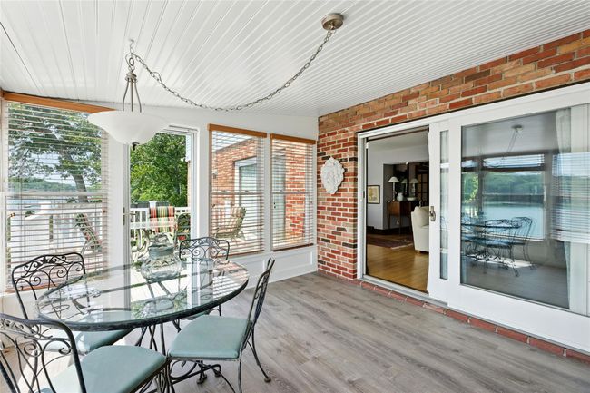 Sunroom / solarium featuring brick wall, wood finished floors, and wooden ceiling | Image 36