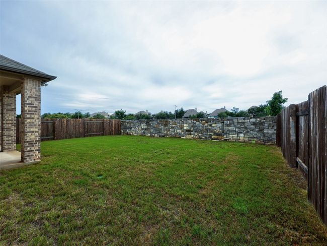 Large yard with pretty stone wall in back | Image 35