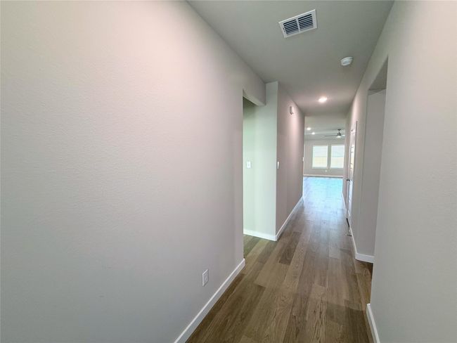 Hall featuring dark wood-style flooring and baseboards | Image 4