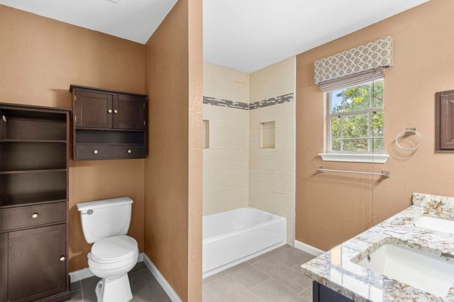 Full bathroom with double vanity, tile patterned floors, and tub / shower combination | Image 23
