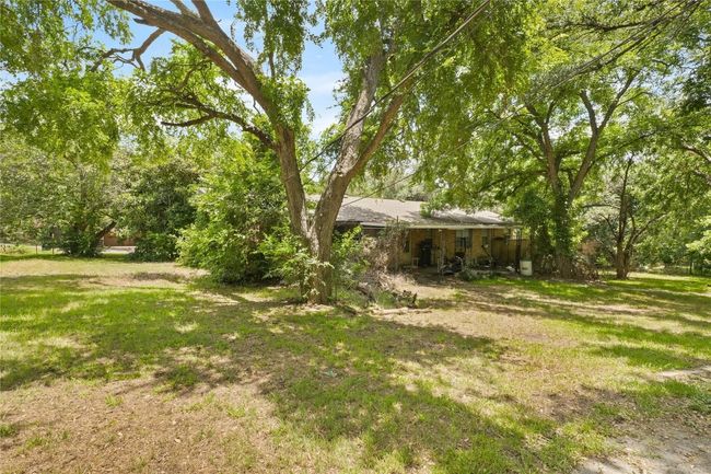 View of grassy yard & wooded area on .49 acre | Image 7
