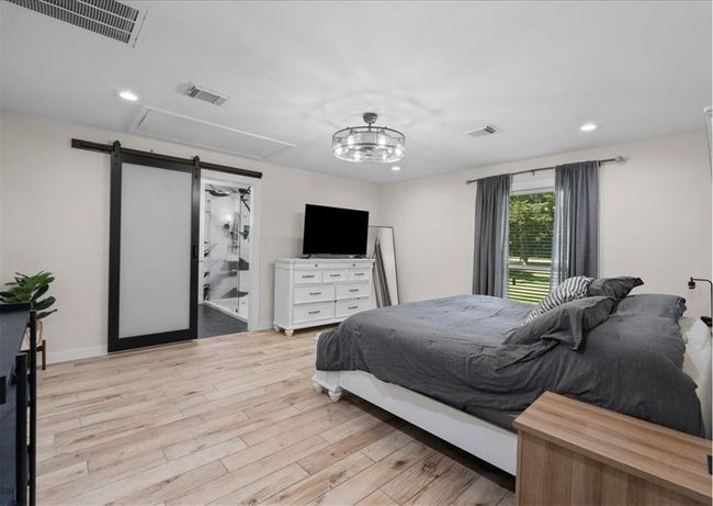 Additional view of the primary suite highlighting natural light and direct access to the luxurious ensuite. | Image 28