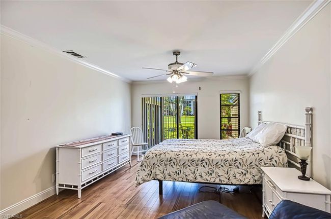 Bedroom with ceiling fan, crown molding, visible vents, baseboards, and hardwood / wood-style floors | Image 32